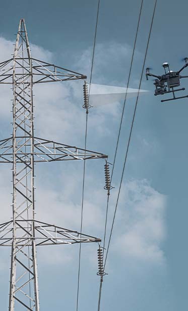 Strommast mit Drohne mit blauem Himmel im Hintergrund