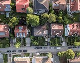 Drohnenaufnahme einer Straße in einer Wohnsiedlung aus der Vogelperspektive
