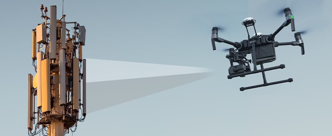 Drohne inspiziert Funkmasten mit blauem Himmel im Hinergrund
