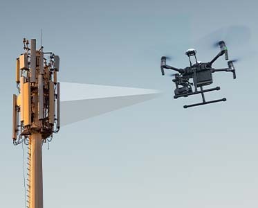 Funkmast mit Drohne mit blauem Himmel im Hintergrund